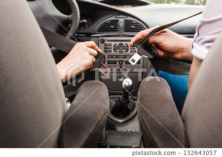 Two people fastening seatbelts Two people fastening seatbelts 132643057