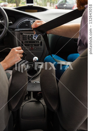 Two people fastening seatbelts Two people fastening seatbelts 132643058