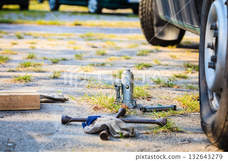 Socket wheel wrench and jack lying on ground Socket wheel wrench and jack lying on ground 132643279