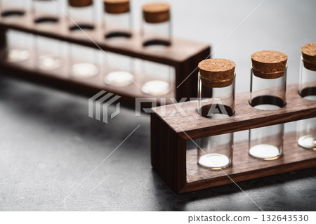 empty walnut holder with glass tubes for spices on concrete surface empty walnut holder with glass tubes for spices on concrete surface 132643530