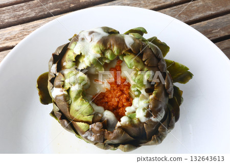 cooked seasonal artichoke with cheese and sobrasada 132643613