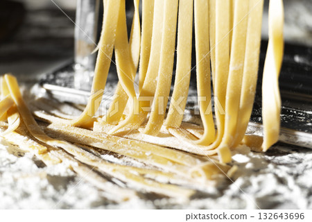 Fresh raw noodles made on home pasta machine closeup low angle view 132643696