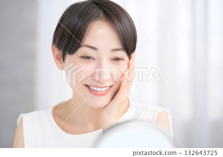 Japanese woman checking her skin in the mirror 132643725