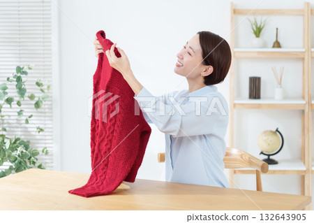A woman taking out a sweater for a change of clothes A woman taking out a sweater for a change of clothes 132643905