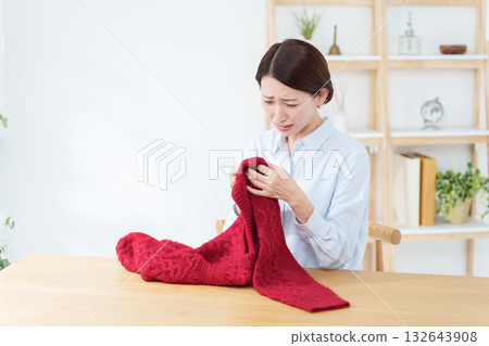 A woman discovers a problem with a sweater she took out for a change of season A woman discovers a problem with a sweater she took out for a change of season 132643908