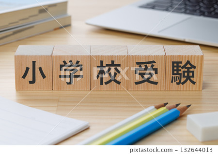 A block with the words "Elementary School Entrance Exam" written on it on a desk 132644013
