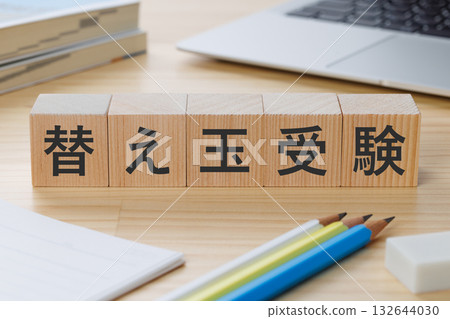 桌上放著一個寫著「代考」字樣的方塊。 桌上放著一個寫著「代考」字樣的方塊。 132644030