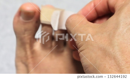 A person putting a bandage on his leg 132644192