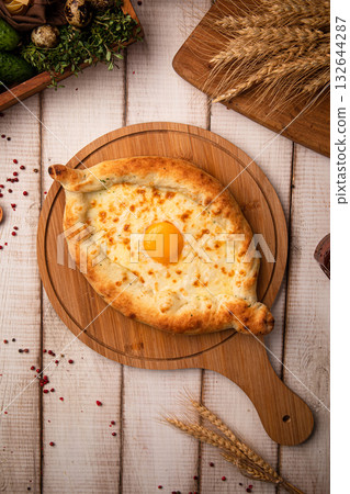 Khachapuri with egg on wooden board Khachapuri with egg on wooden board 132644287