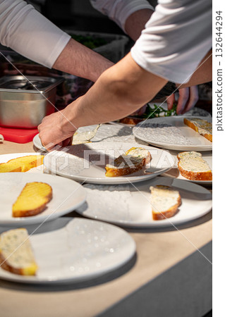 Chef prepares bruschetta with fresh greens 132644294