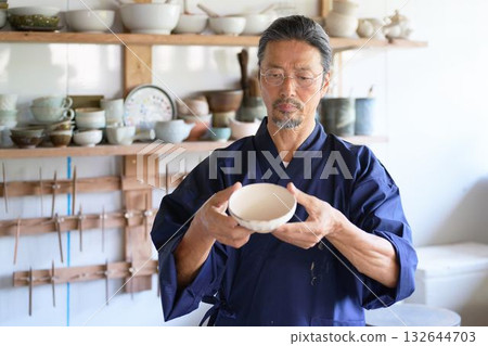 A veteran potter checking out the work 132644703