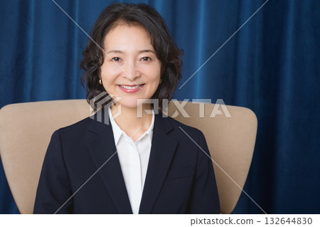 坐在大椅子上的中年女商人 132644830