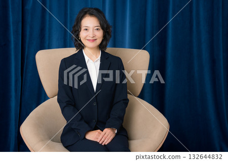 坐在大椅子上的中年女商人 132644832