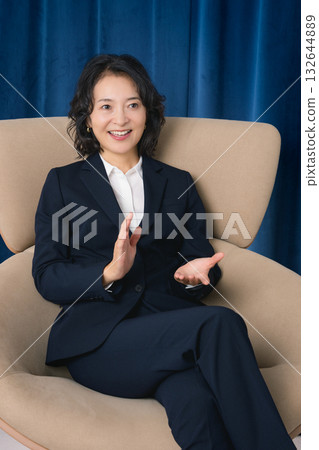 一位事業中期的女性自信地談論著商業。 一位事業中期的女性自信地談論著商業。 132644889