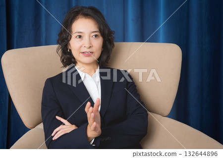 一位事業中期的女性自信地談論著商業。 一位事業中期的女性自信地談論著商業。 132644896