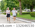 Two Asian senior women exercise with jogging along the road in the garden with day light. 132646530