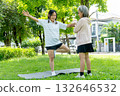 Asian senior woman stand and help her friend to exercise with yoga with spread arms out in garden with day light. 132646532