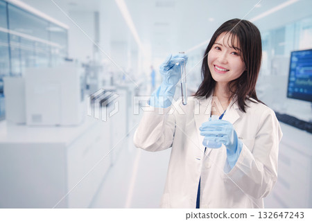 一位年輕女子在實驗室的試管裡操作化學物質。 132647243