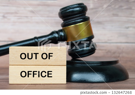 Out of office text on wooden blocks with gavel background. Getaway or on a vacation concept. Out of office text on wooden blocks with gavel background. Getaway or on a vacation concept. 132647268