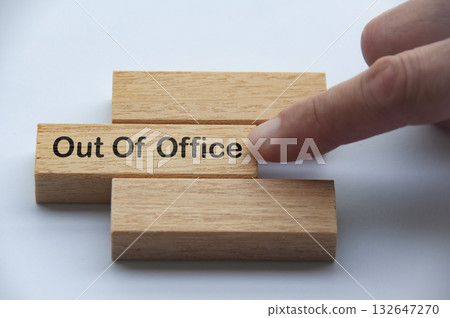 Out of office text on wooden blocks with hand pushing it. Getaway or on a vacation concept. 132647270