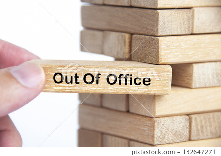 Hand pulling out wooden block with out of office text on it. Getaway or on a vacation concept. Hand pulling out wooden block with out of office text on it. Getaway or on a vacation concept. 132647271