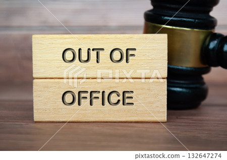 Out of office text engraved on wooden blocks with gavel background. Getaway or on a vacation concept. 132647274