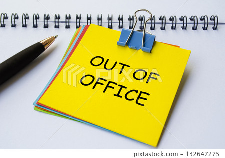 Out of office text on yellow notepad with white notebook background. Getaway or on a vacation concept. 132647275