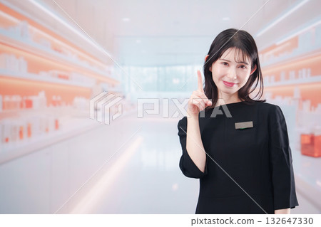 一位年輕的女售貨員正在化妝品店為顧客服務 一位年輕的女售貨員正在化妝品店為顧客服務 132647330