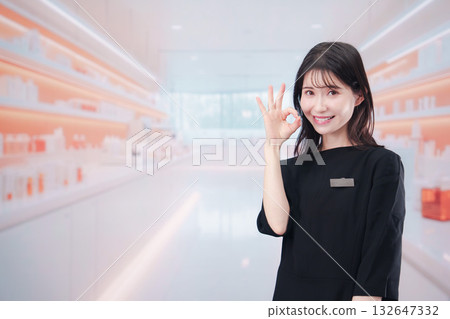 一位年輕的女售貨員正在化妝品店為顧客服務 一位年輕的女售貨員正在化妝品店為顧客服務 132647332