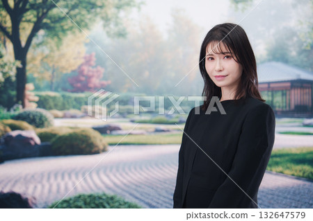 A young woman attending a funeral in mourning clothes A young woman attending a funeral in mourning clothes 132647579