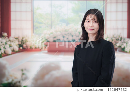 A young woman attending a funeral in mourning clothes A young woman attending a funeral in mourning clothes 132647582