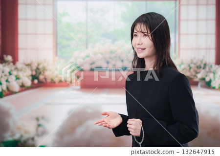 葬禮上，一位身著喪服、手持念珠的年輕女子正在參加葬禮。 132647915