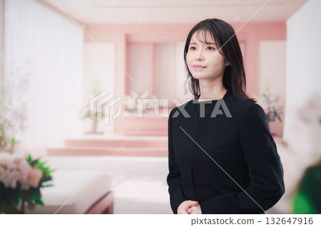 Young woman wearing mourning clothes and holding prayer beads at a funeral Young woman wearing mourning clothes and holding prayer beads at a funeral 132647916