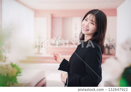 Young woman wearing mourning clothes and holding prayer beads at a funeral Young woman wearing mourning clothes and holding prayer beads at a funeral 132647922