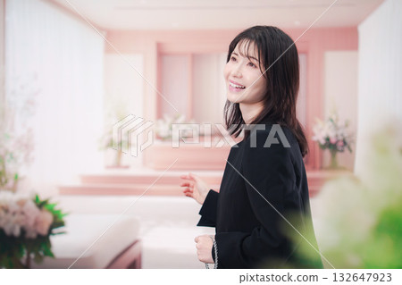 Young woman wearing mourning clothes and holding prayer beads at a funeral Young woman wearing mourning clothes and holding prayer beads at a funeral 132647923
