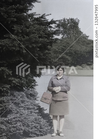 Vintage portrait of a young attractive woman dressed in 1960s fashion. Retro photo from 1969. 132647995
