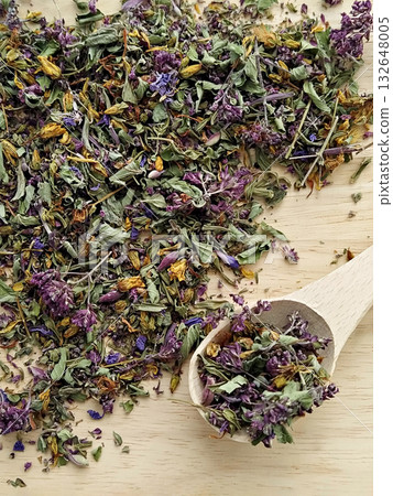 Dried meadow herbs and petals mix on wooden board with spoon, colorful mint oregano and cornflower creating fragrant natural blend Dried meadow herbs and petals mix on wooden board with spoon, colorful mint oregano and cornflower creating fragrant natural blend 132648005