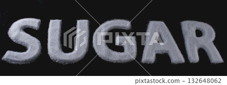 White sugar arranged in bold letters on a dark background in a creative kitchen setting 132648062