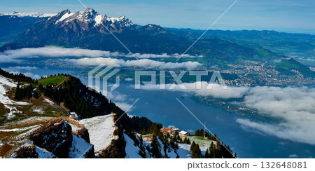 Breathtaking view of mountains and lake during clear weather in Switzerland with clouds lingering in the valley 132648081
