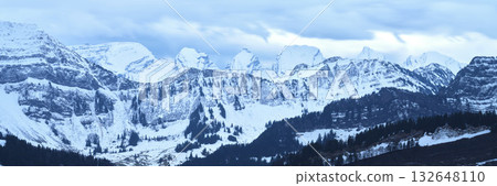 Majestic snow-covered mountain range under a cloudy sky in the early morning light Majestic snow-covered mountain range under a cloudy sky in the early morning light 132648110