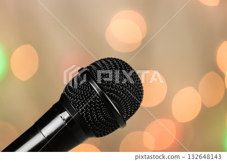 A close-up of a microphone on a concert stage. Spotlights in the blurred background. 132648143
