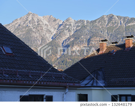 Mountain view with rooftops at sunset in a picturesque alpine village Mountain view with rooftops at sunset in a picturesque alpine village 132648179