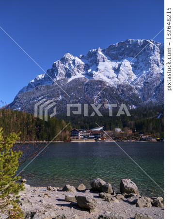 Scenic winter landscape with mountains and lake in a tranquil alpine setting during bright daylight Scenic winter landscape with mountains and lake in a tranquil alpine setting during bright daylight 132648215