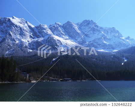 Snowy mountain range reflects in clear lake during sunny day, showcasing natural beauty and outdoor adventure Snowy mountain range reflects in clear lake during sunny day, showcasing natural beauty and outdoor adventure 132648222
