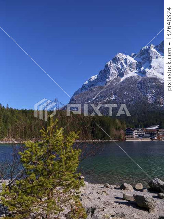 Majestic mountains and clear lake under blue sky on a sunny day in a serene landscape 132648324