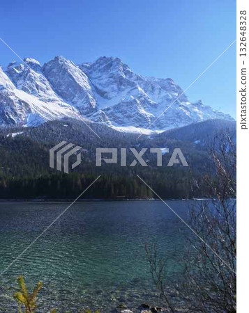 Stunning mountain landscape with clear lake under bright blue sky during daytime 132648328