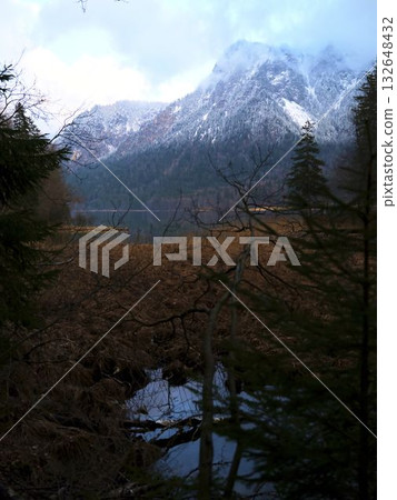 Scenic view of mountains and lake reflecting autumn colors in a tranquil forest setting 132648432