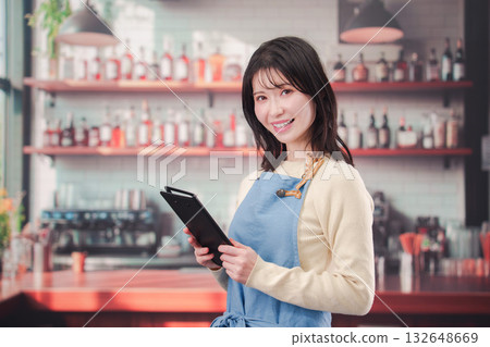 在咖啡館/酒吧工作的年輕女員工 在咖啡館/酒吧工作的年輕女員工 132648669