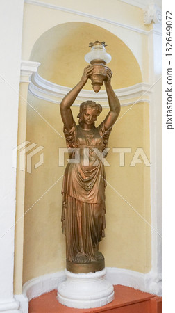 Bronze Statue Roman woman holding a torch, Lady lamp, Isolated on yellow wall background. Bronze Statue Roman woman holding a torch, Lady lamp, Isolated on yellow wall background. 132649072
