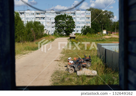 A peaceful and quiet street view showcasing a residential building surrounded by lush greenery A peaceful and quiet street view showcasing a residential building surrounded by lush greenery 132649162